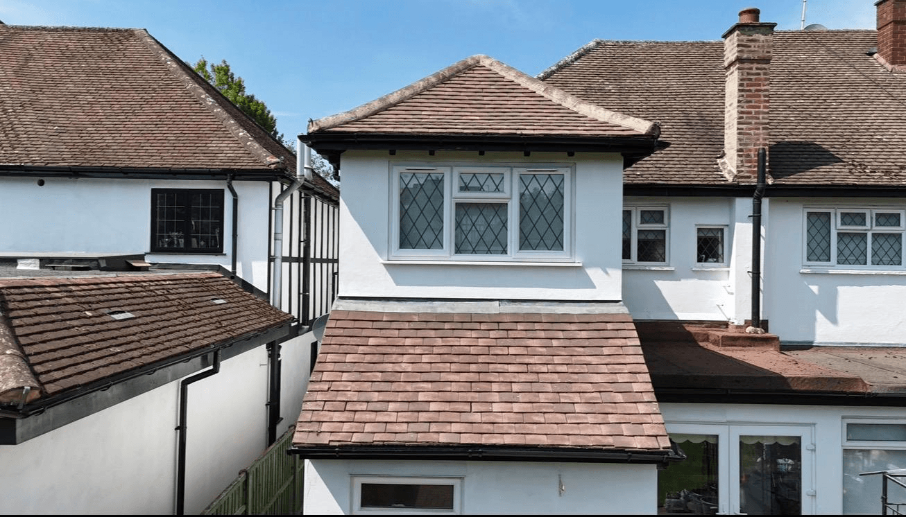 Same semi-detached house with clean golden terracotta roof tiles after cleaning