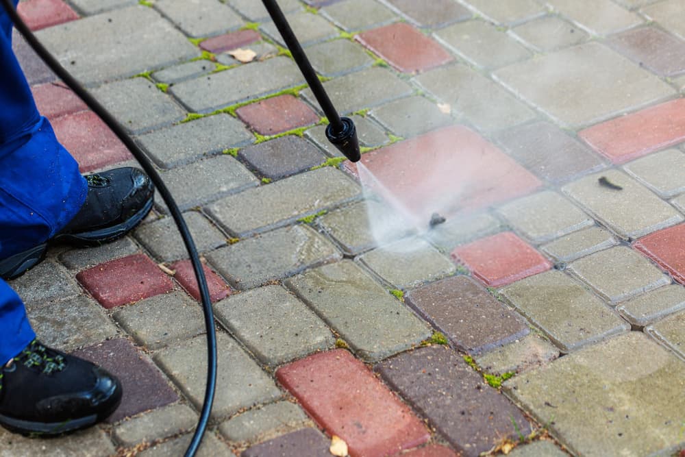 Block paving driveway being pressure washed clean