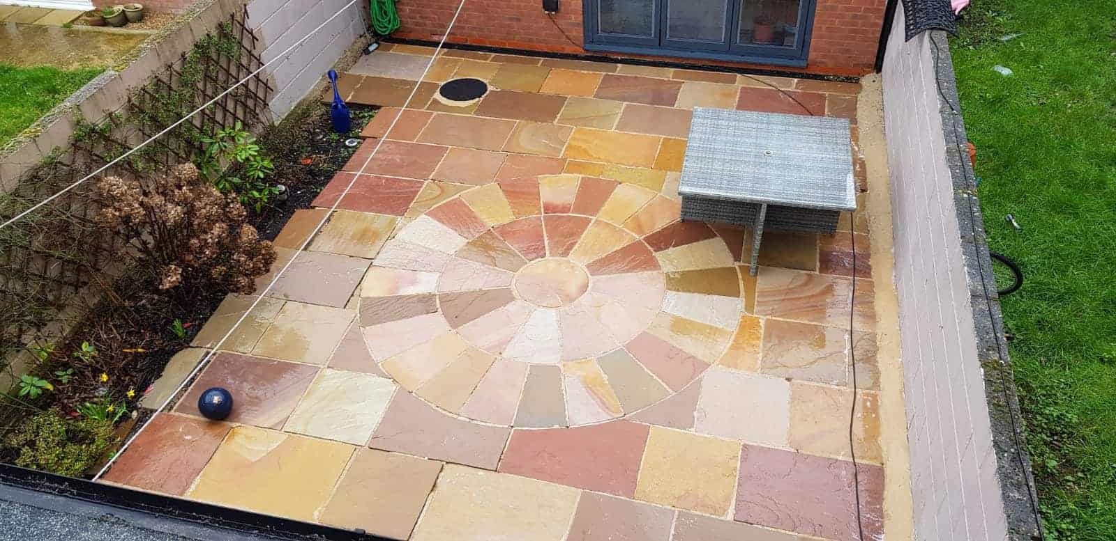 Stone patio slabs being cleaned with a pressure washer